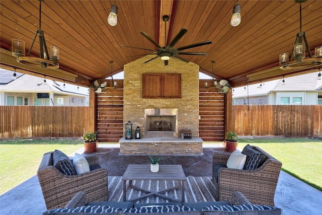 view of patio / terrace featuring ceiling fan, a fenced backyard, and an outdoor living space with a fireplace