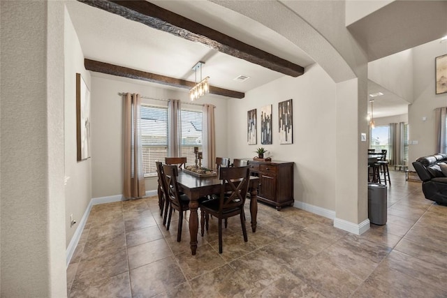 tiled dining area with beamed ceiling and baseboards