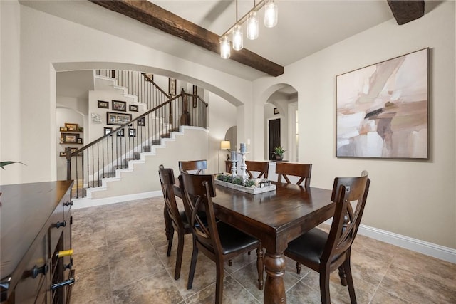 dining room featuring beam ceiling, stairway, baseboards, and arched walkways