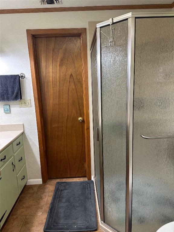 bathroom featuring baseboards, visible vents, a shower stall, and vanity