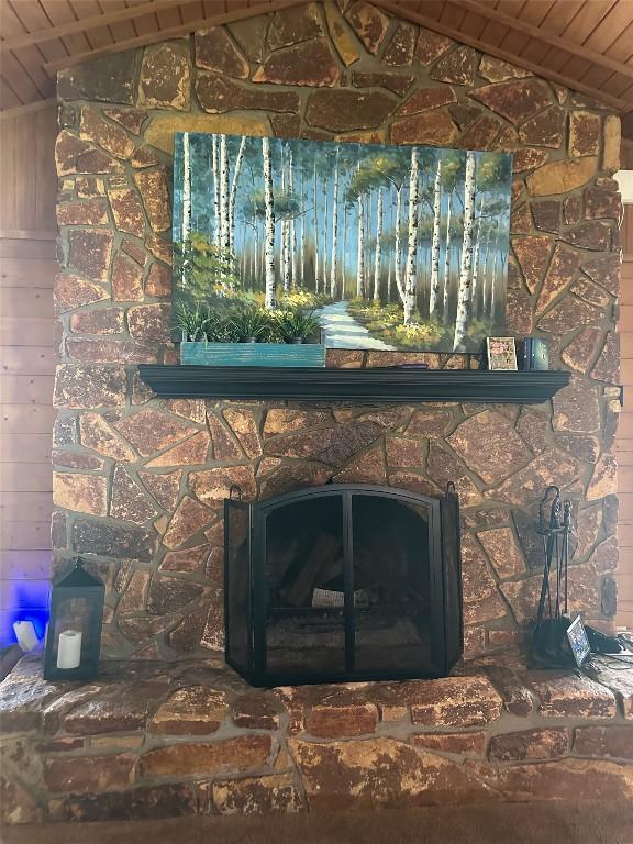 room details featuring wooden ceiling, wood walls, and a fireplace