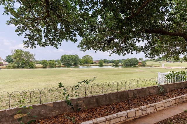 view of yard featuring a water view and fence