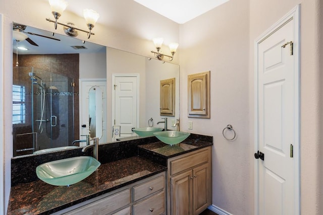 full bathroom featuring ceiling fan, a sink, double vanity, visible vents, and a stall shower
