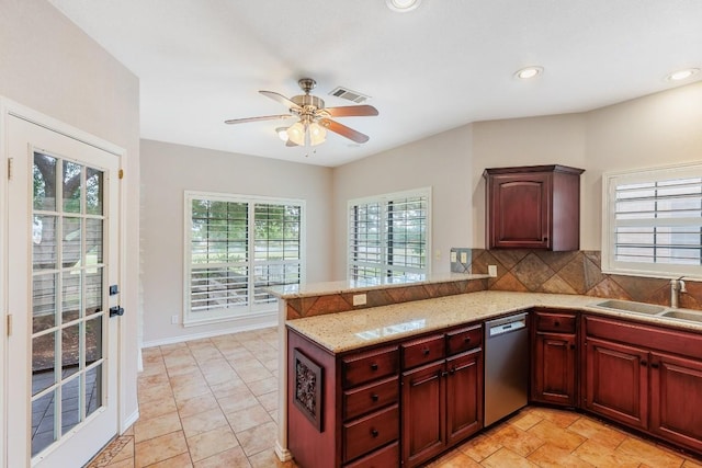 kitchen with a sink, stainless steel dishwasher, a peninsula, and reddish brown cabinets