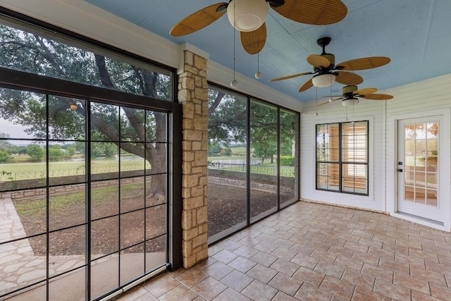 unfurnished sunroom with a ceiling fan