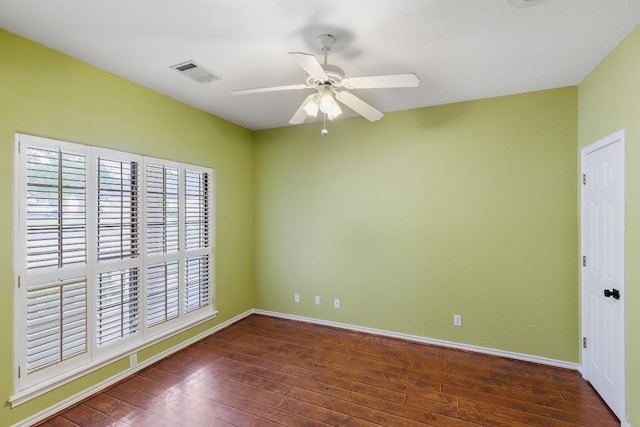 unfurnished room with visible vents, baseboards, and hardwood / wood-style floors
