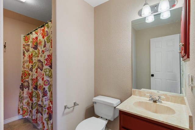 bathroom featuring vanity, tile patterned flooring, toilet, and curtained shower