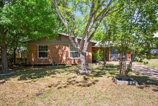 view of front of home with brick siding and a front yard