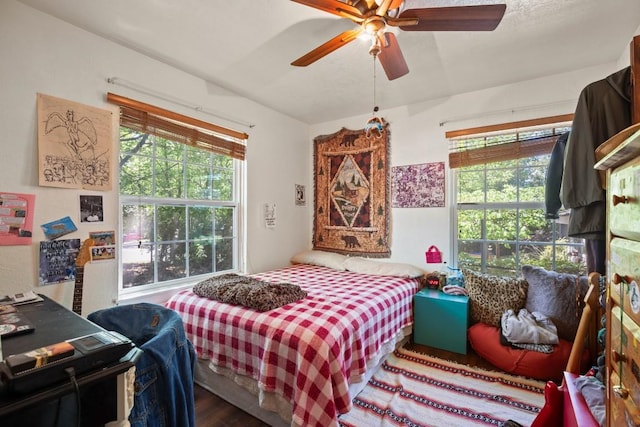 bedroom with wood finished floors, a ceiling fan, and multiple windows