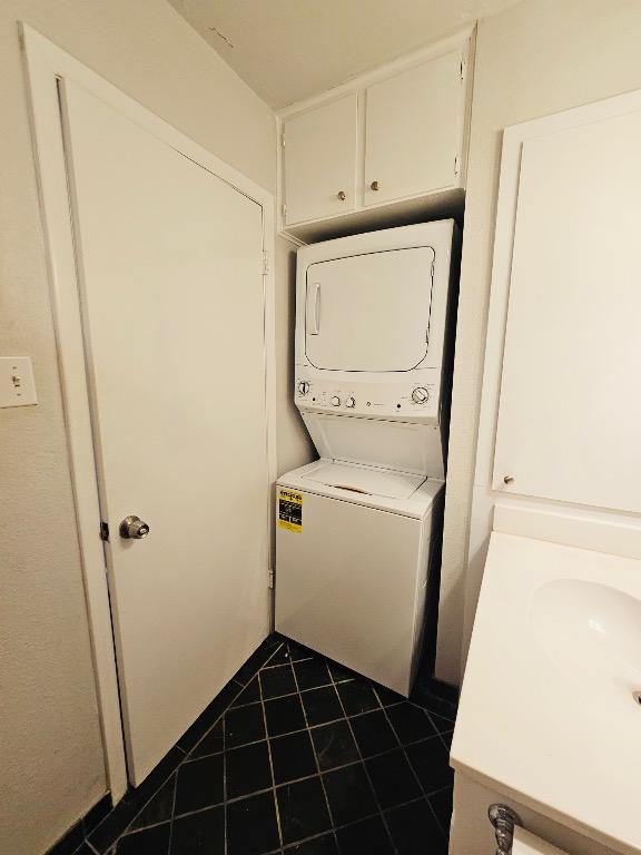 5107 Leralynn St Unit 304, Austin, TX 78751 - laundry room with stacked washer / dryer and dark tile patterned flooring