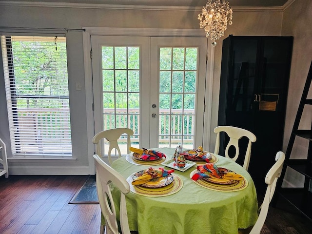 dining area featuring an inviting chandelier, french doors, crown molding, and dark wood finished floors