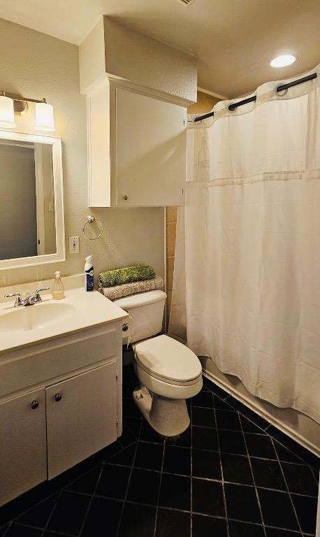 bathroom featuring tile patterned floors, vanity, toilet, and shower / tub combo with curtain