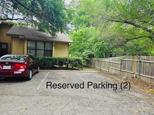 uncovered parking lot featuring fence