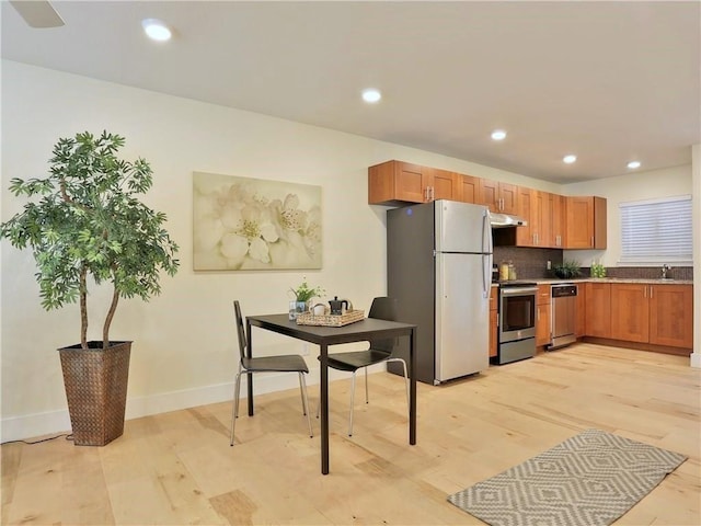 909 Reinli St Unit 241, Austin, TX 78751 - kitchen with stainless steel appliances, under cabinet range hood, light wood-style floors, recessed lighting, and tasteful backsplash