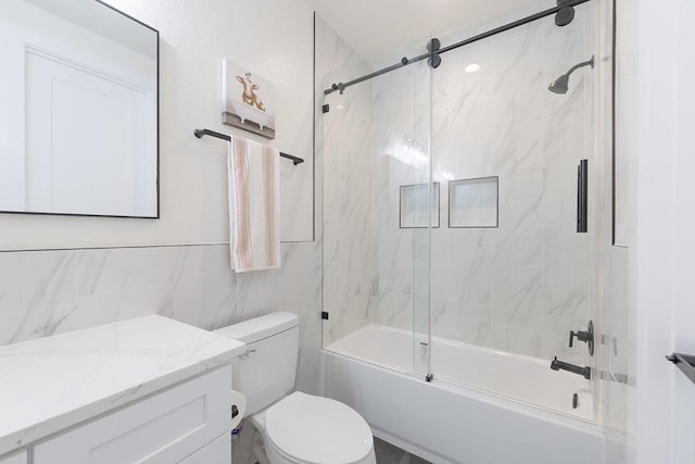 bathroom with toilet, tile walls, enclosed tub / shower combo, and vanity