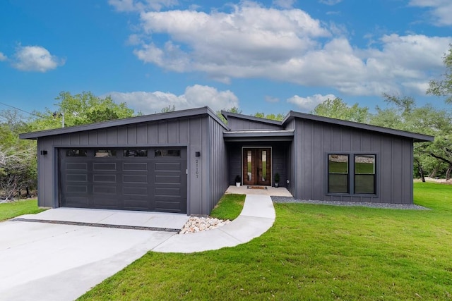 view of front of property with a front yard, concrete driveway, a garage, and board and batten siding