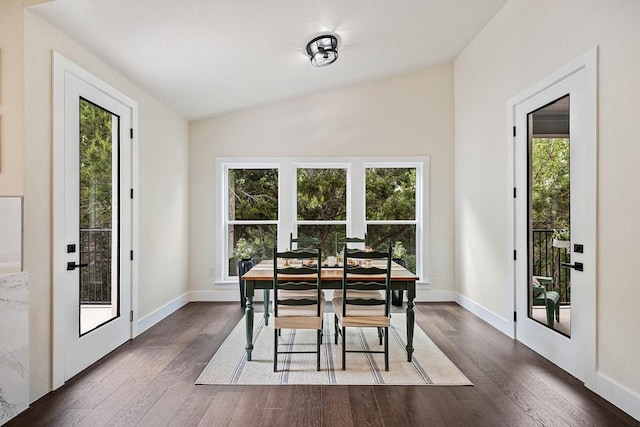 dining room featuring dark wood-style floors, baseboards, a healthy amount of sunlight, and vaulted ceiling