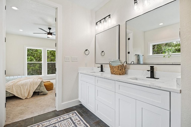 bathroom featuring ceiling fan, ensuite bath, double vanity, and a sink