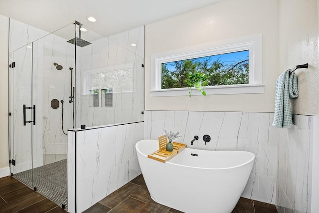 full bathroom with a marble finish shower, a wainscoted wall, tile walls, and a freestanding tub