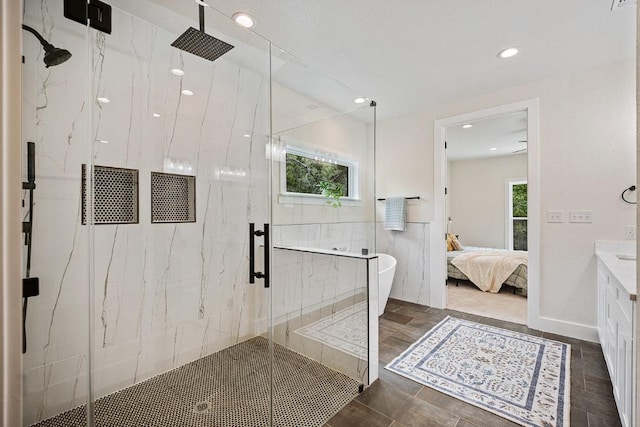 ensuite bathroom with a wealth of natural light, connected bathroom, and a marble finish shower