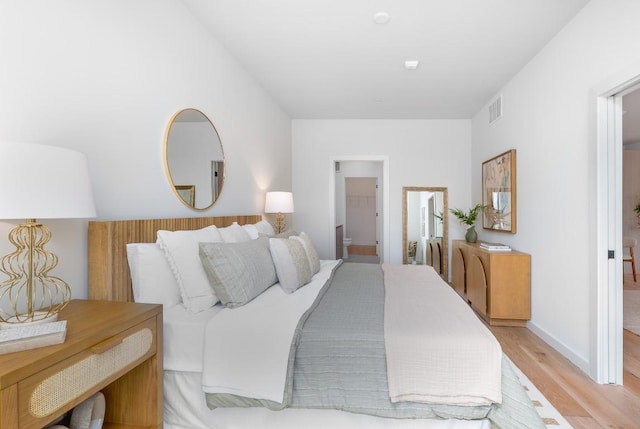 2209 S 1st St Unit 313, Austin, TX 78704 - bedroom with light wood finished floors, baseboards, and connected bathroom
