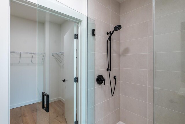 2209 S 1st St Unit 313, Austin, TX 78704 - bathroom with a stall shower, wood finished floors, and a spacious closet