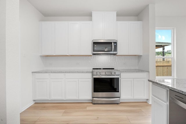121 Coastal Way, Georgetown, TX 78628 - kitchen with appliances with stainless steel finishes, light wood-type flooring, and white cabinetry