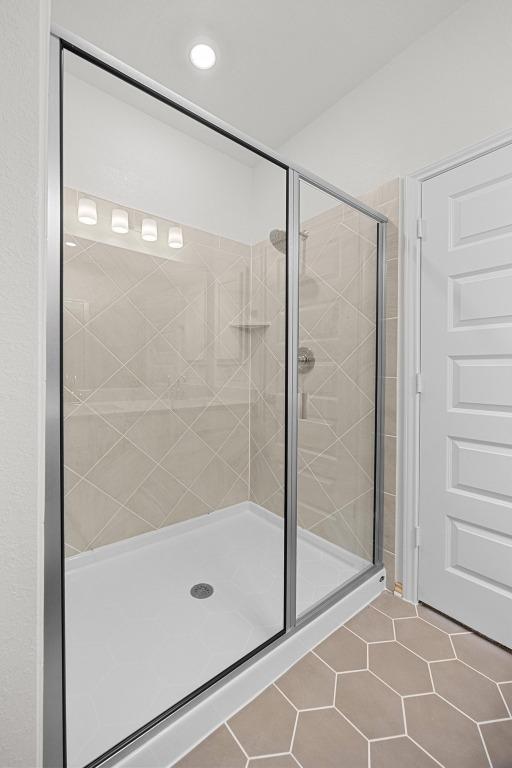 121 Coastal Way, Georgetown, TX 78628 - bathroom featuring a stall shower, tile patterned floors, and recessed lighting