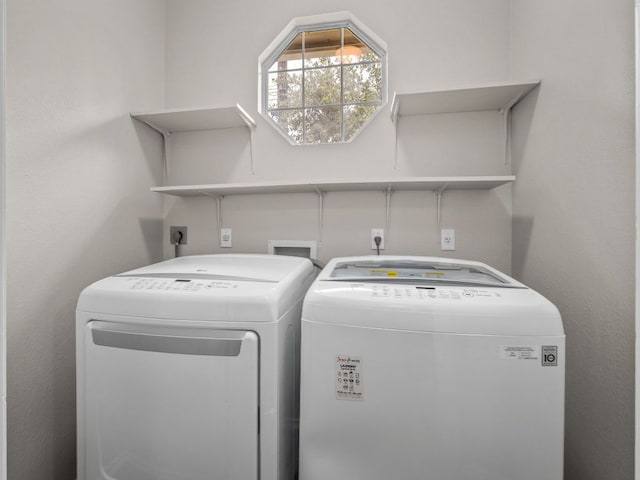 washroom with washing machine and clothes dryer and laundry area