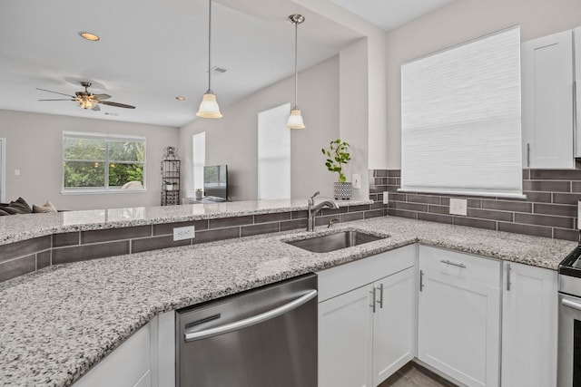 kitchen with appliances with stainless steel finishes, white cabinetry, ceiling fan, and light stone counters