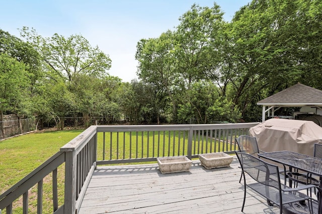 deck with a lawn, area for grilling, and a fenced backyard