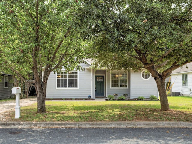 view of property hidden behind natural elements with a front yard