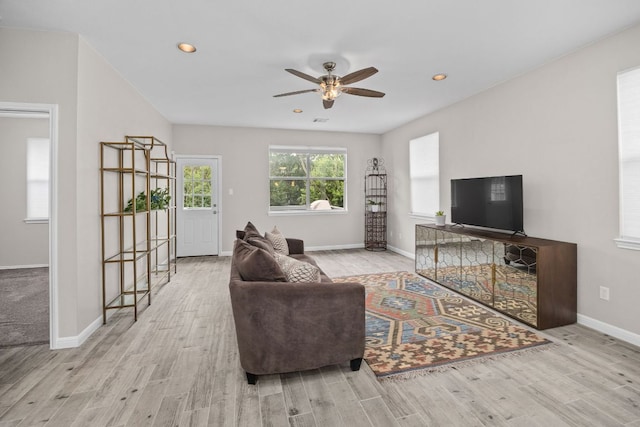 living area with a ceiling fan and wood finished floors