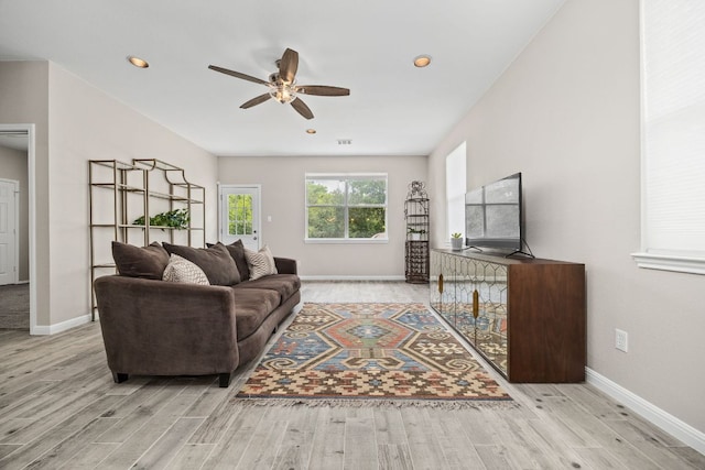 living room with wood finished floors, ceiling fan, and baseboards