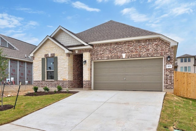 109 Coastal Way, Georgetown, TX 78628 - view of front of house featuring concrete driveway, brick siding, a shingled roof, a garage, and stone siding