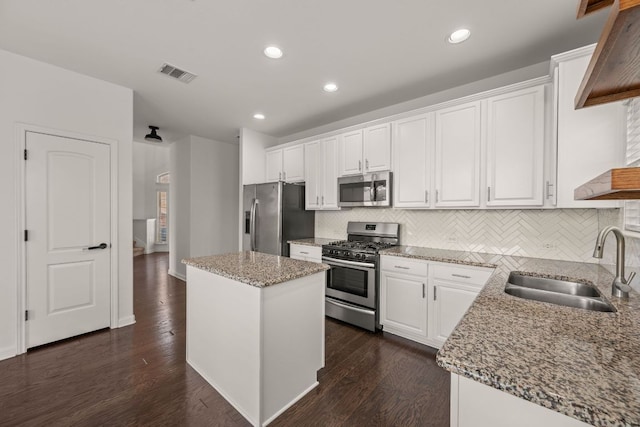 117 Rock Mill Loop, Georgetown, TX 78626 - kitchen featuring stainless steel appliances, a sink, a center island, backsplash, and white cabinets