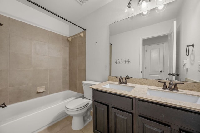 full bathroom with double vanity, toilet, tile patterned floors, and a sink