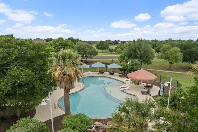 pool with a patio and fence