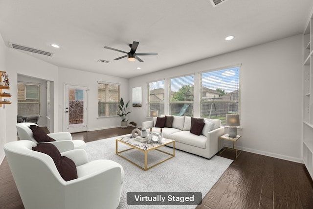 living area featuring baseboards, ceiling fan, visible vents, and wood finished floors