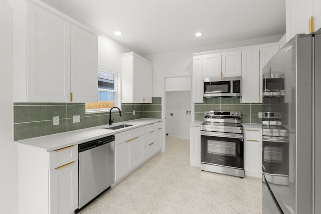kitchen with white cabinetry, decorative backsplash, a sink, appliances with stainless steel finishes, and light countertops
