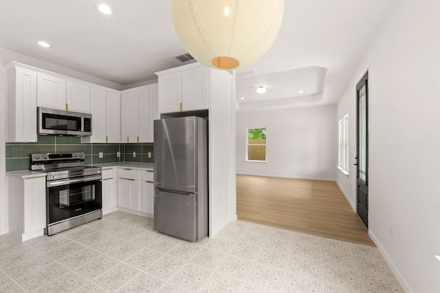 kitchen with white cabinetry, decorative backsplash, appliances with stainless steel finishes, light countertops, and recessed lighting