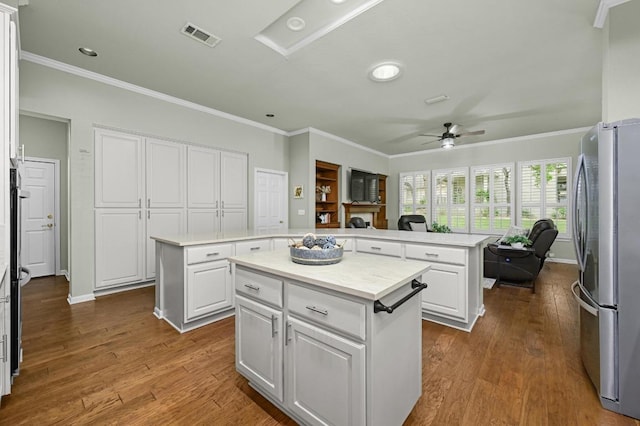 112 Hill Country Dr, Georgetown, TX 78633 - kitchen featuring freestanding refrigerator, a kitchen island, ceiling fan, crown molding, and light countertops