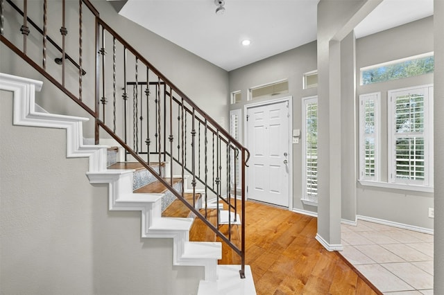 foyer with stairway, wood finished floors, recessed lighting, and baseboards