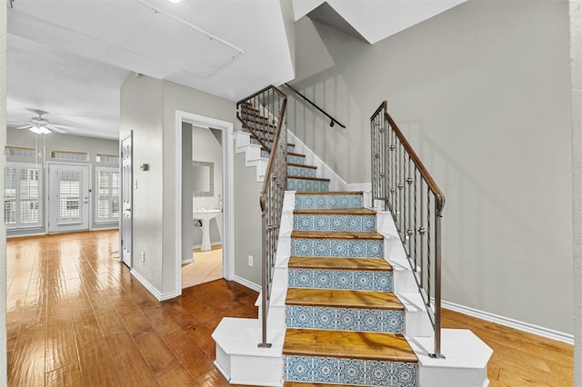 staircase with ceiling fan, baseboards, and wood-type flooring