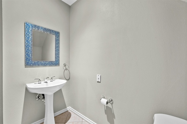 bathroom with tile patterned floors, baseboards, and toilet
