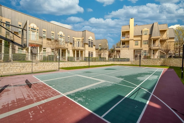 view of basketball court with fence and a residential view