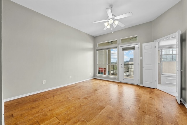 unfurnished room featuring a ceiling fan, light wood finished floors, and baseboards