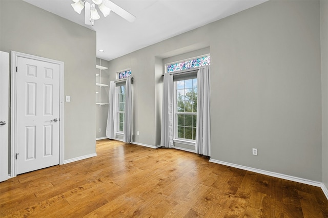 unfurnished room with wood finished floors, ceiling fan, and baseboards