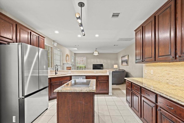 kitchen featuring a sink, stainless steel appliances, a center island, open floor plan, and recessed lighting