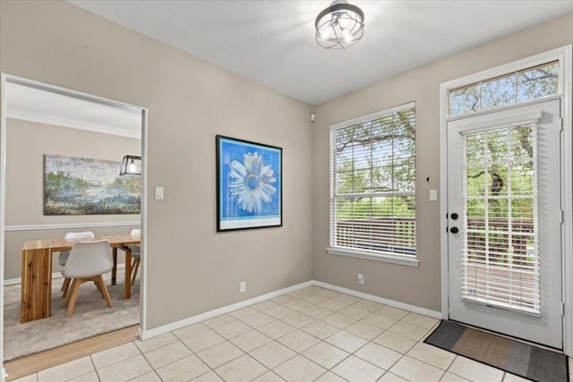 doorway featuring light tile patterned flooring and baseboards